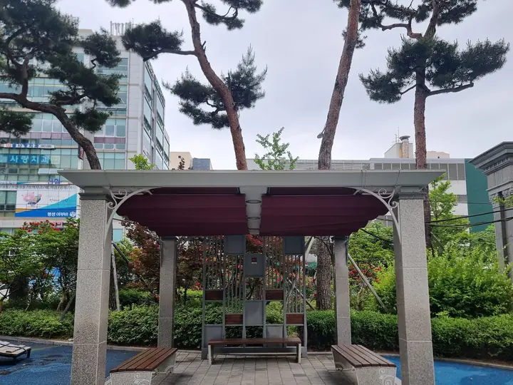 소나무 아래 퍼걸러가 있는 놀이터
