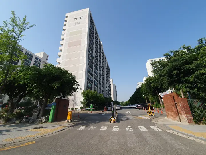 붉은 벽돌 문기둥 너머 고층 동
