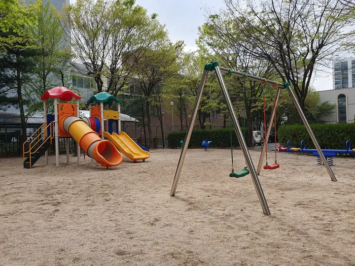 그네와 미끄럼틀이 있는 모래 놀이터