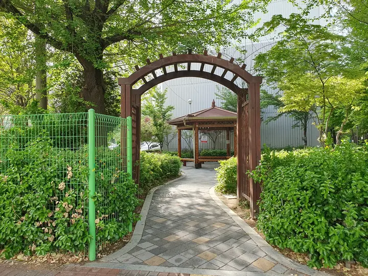 아치 문 너머 정자로 이어지는 정원 길