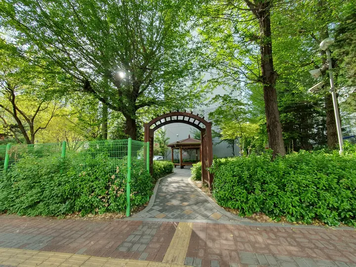 보도 옆 정원 입구의 목재 아치