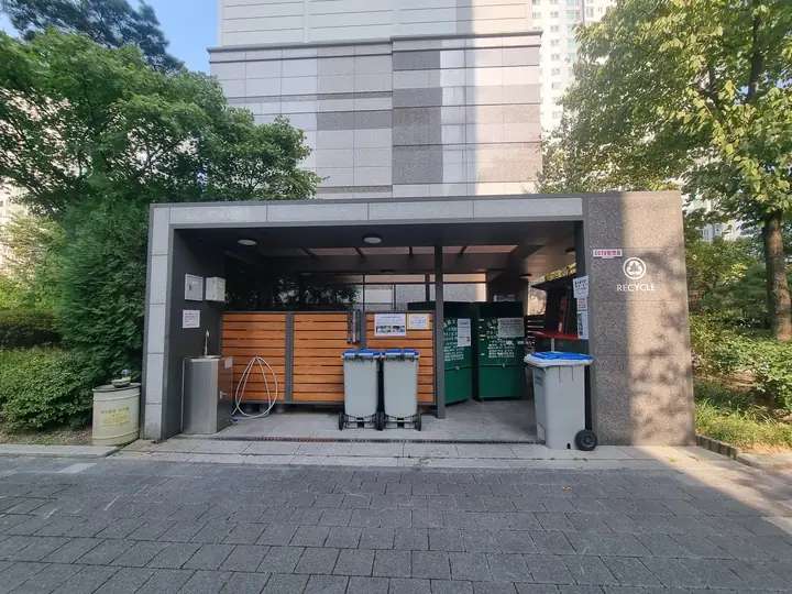 목재 칸막이와 수전이 있는 분리수거장